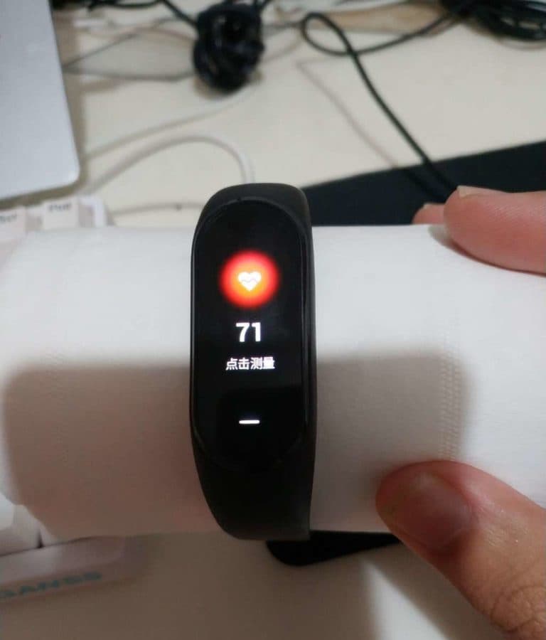 Фитнес-браслет Xiaomi Mi Band 3 находит пульс у салфетки Фитнес-браслет Xiaomi Mi Band 3 находит пульс у салфетки