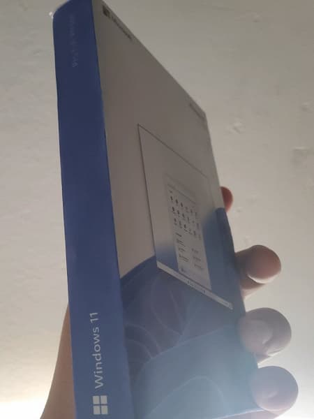 С новым меню Пуск в самом центре. На фото показали коробку Windows 11 Pro